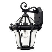 Hinkley San Clemente black wall lantern with curved clear glass, a curled support and a decorative centre band