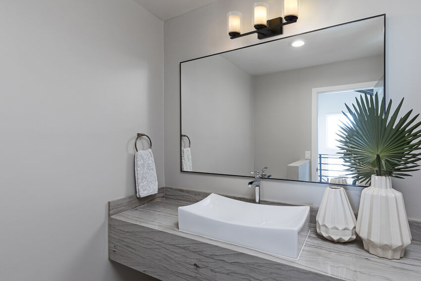 Z-Lite Willow three-light Matte Black vanity light installed above a bathroom mirror