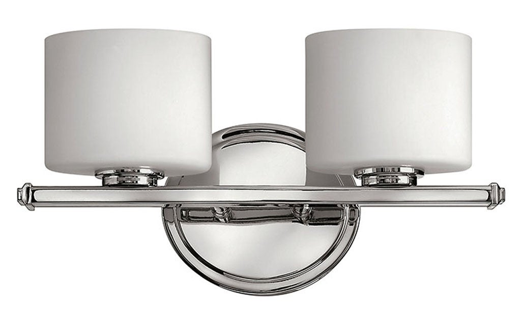 Hinkley Ocho chrome vanity light with two white cylindrical shades, a slim bar and round backplate.
