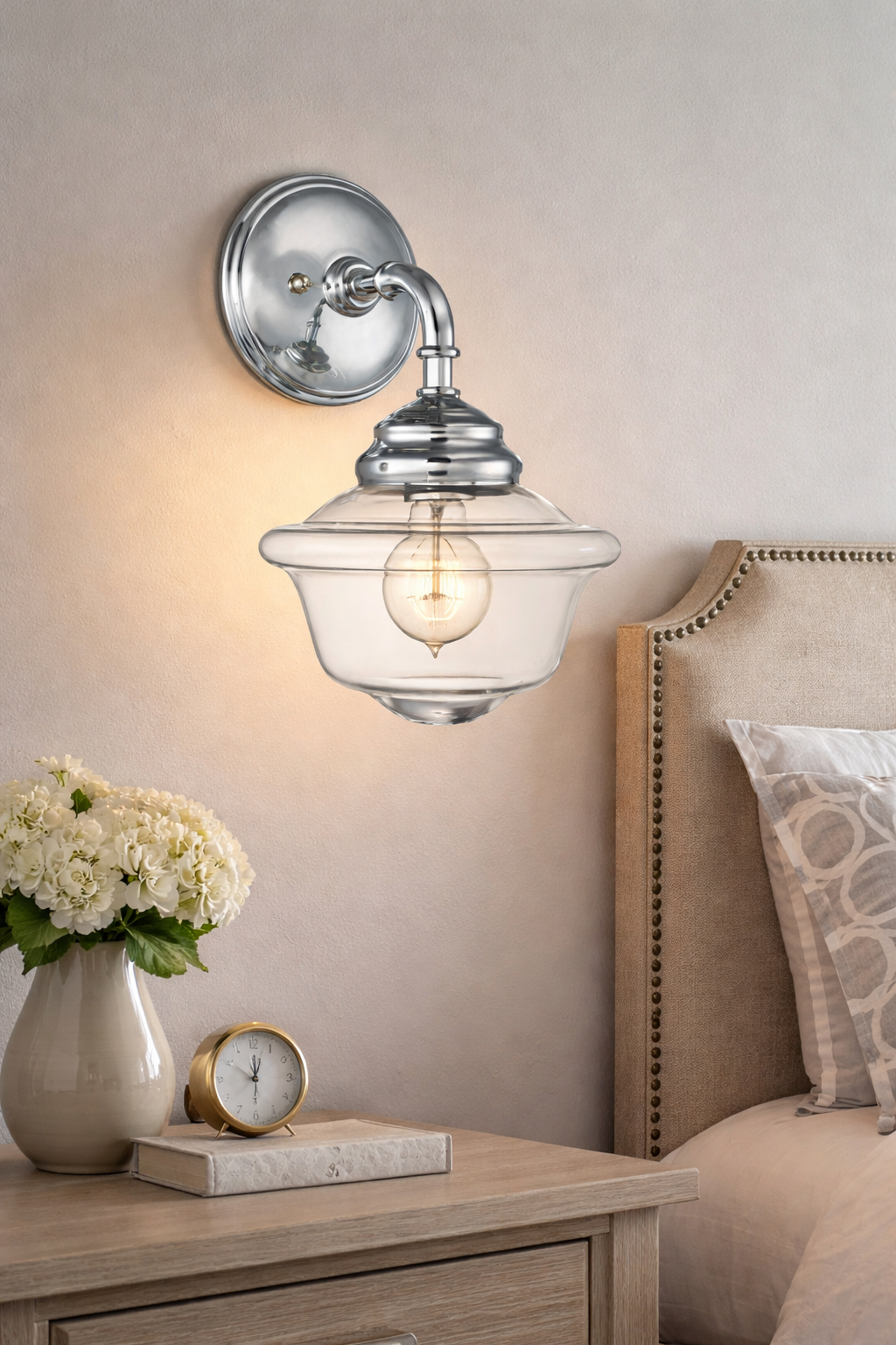 Fairfield chrome wall sconce with a clear shaped bowl and stepped cap beside a bed.