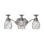Hinkley Plantation polished antique nickel vanity light showing textured pineapple glass and leaf crowns.