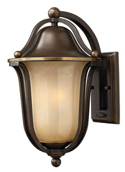 Hinkley Bolla Olde Bronze outdoor wall lantern with curved straps, an amber textured bowl and rounded finial details.