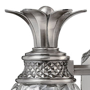 Close-up of the Hinkley Plantation sconce's flared metal leaf crown and textured collar