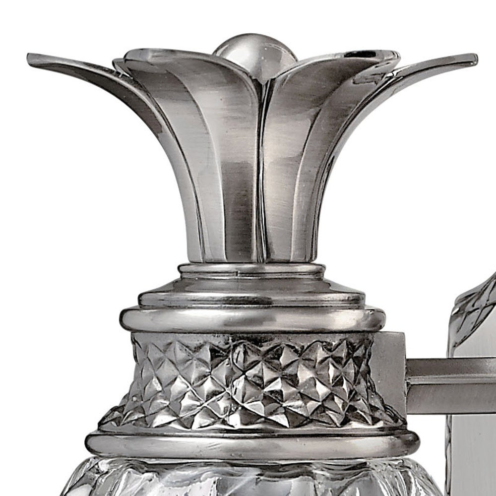 Close-up of the Hinkley Plantation sconce's flared metal leaf crown and textured collar
