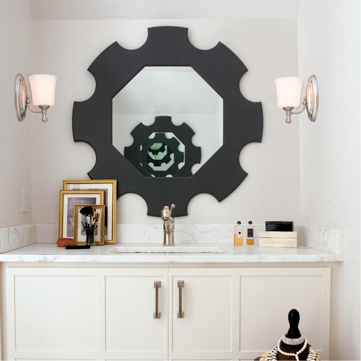 Two separate Hinkley Shelly chrome sconces flanking a decorative dark mirror