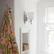 Side view of a Hinkley Shelly chrome sconce installed near a window and wall hook