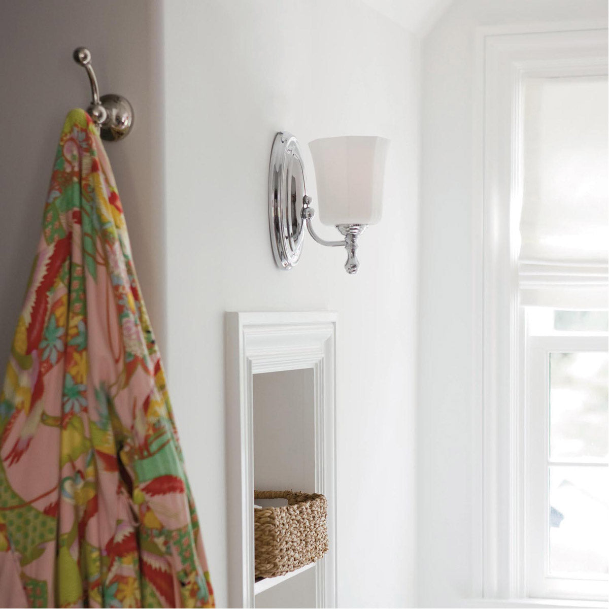 Side view of a Hinkley Shelly chrome sconce installed near a window and wall hook