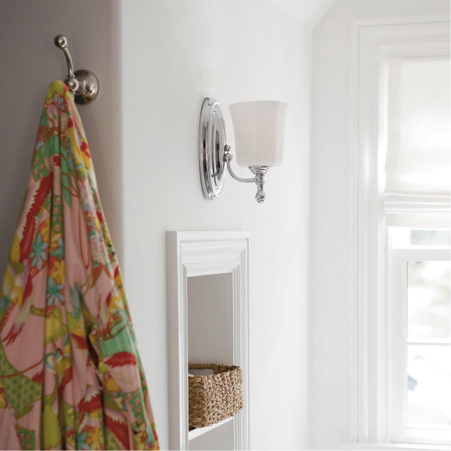Side view of a Hinkley Shelly chrome sconce installed near a window and wall hook