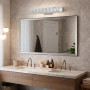 Kuzco Gamma crystal wall sconce mounted above a large mirror in a bathroom setting.