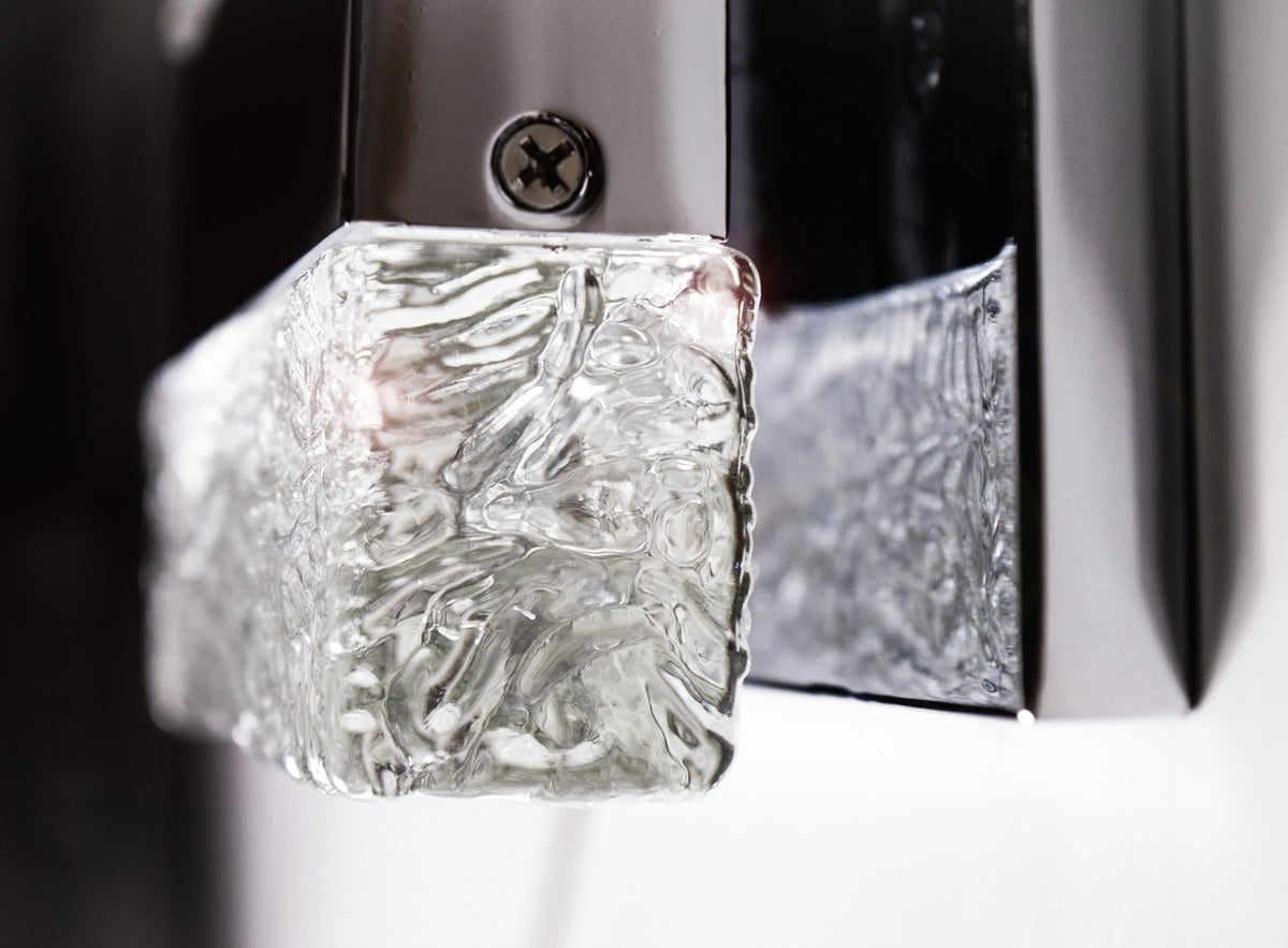 Close-up of a textured clear block corner, retaining edge and screw on the Maxim Ice wall light.