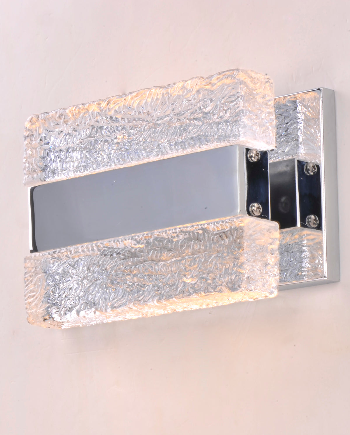 Front-angle view of textured clear blocks, side screws and reflective backplate on the Maxim Ice wall light.