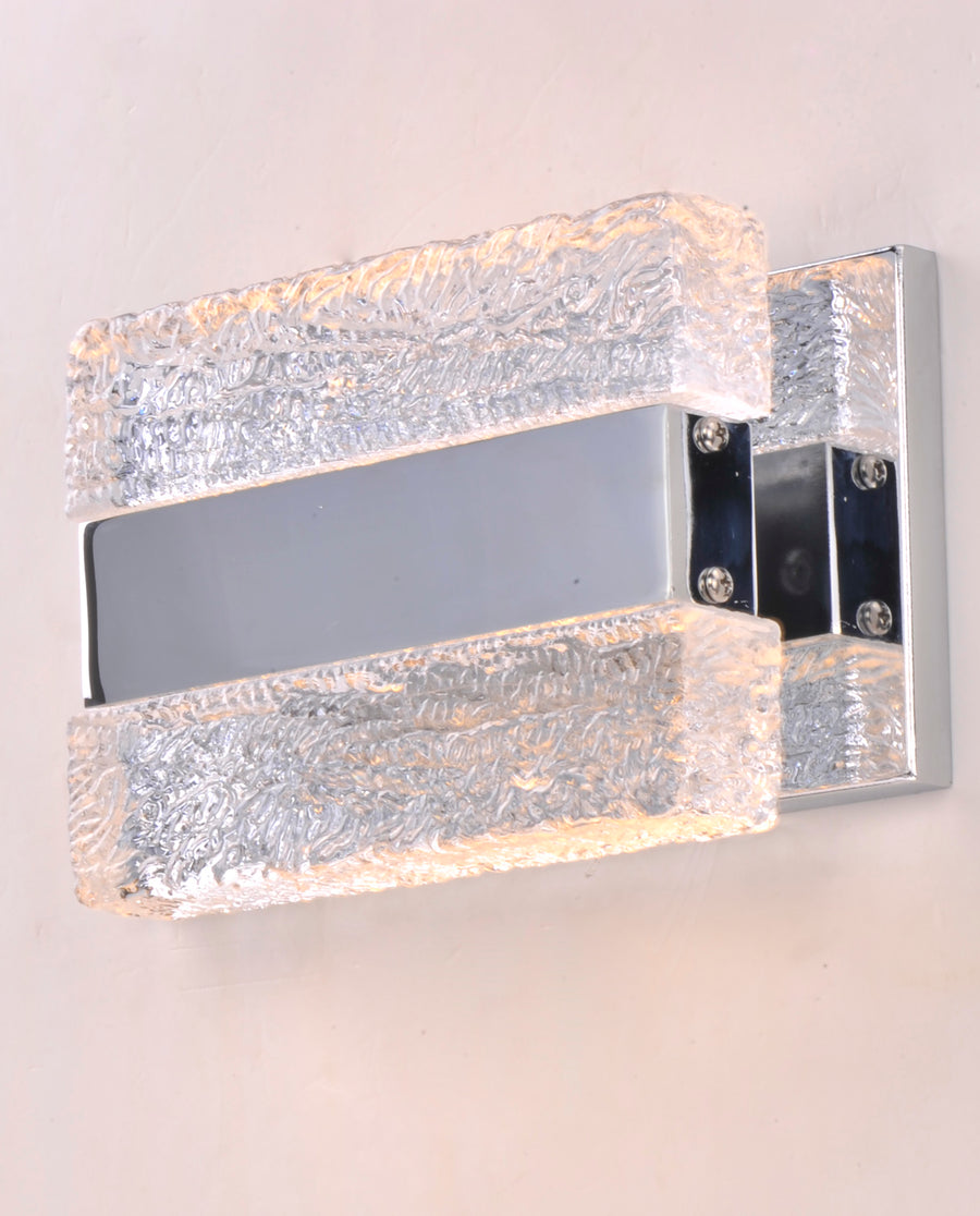 Front-angle view of textured clear blocks, side screws and reflective backplate on the Maxim Ice wall light.