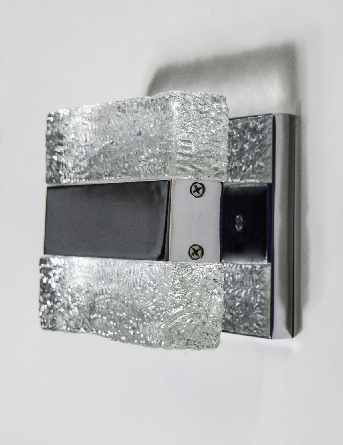 Unlit Maxim Ice wall light showing colourless textured blocks and reflective metal trim.