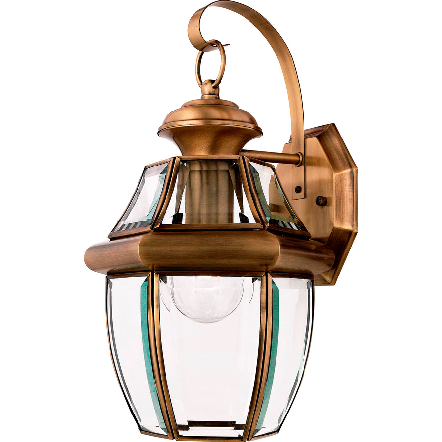 Quoizel Newbury wall lantern with an Antique Brass frame, curved arm and clear beveled glass