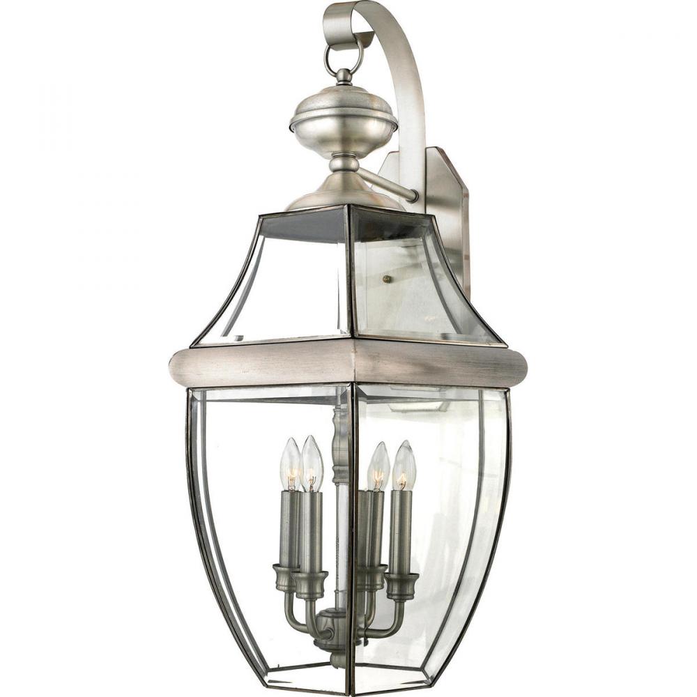 Quoizel Newbury NY8339P pewter wall lantern with a curled support arm, clear glass enclosure and four visible candle lamps