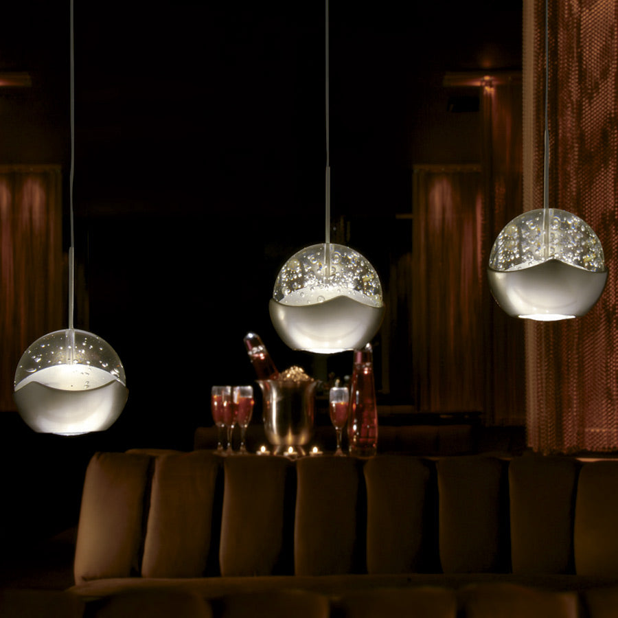 WAC Genesis brushed nickel seeded-glass LED pendants illuminated in a dining lounge application