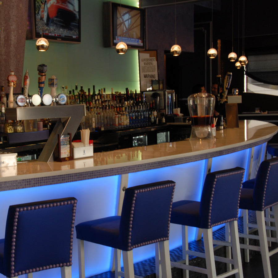 WAC Genesis MP-LED311 brushed nickel LED pendants installed in a row over a bar